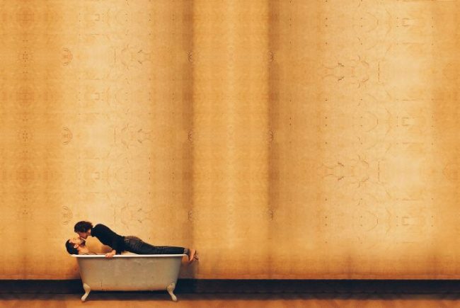 A woman kissing a man in a bath