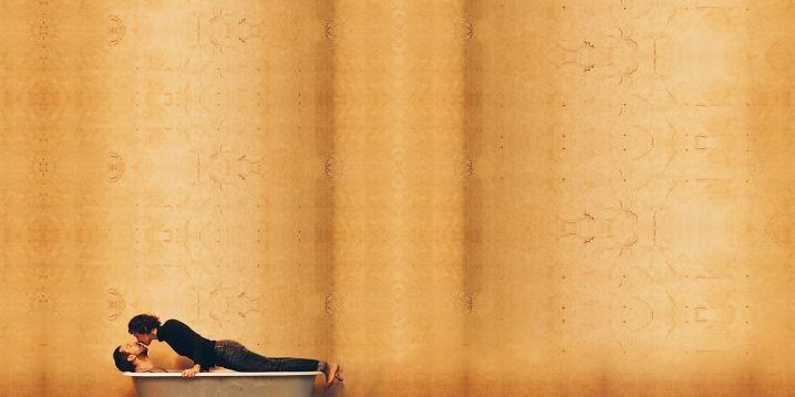 A woman kissing a man in a bath